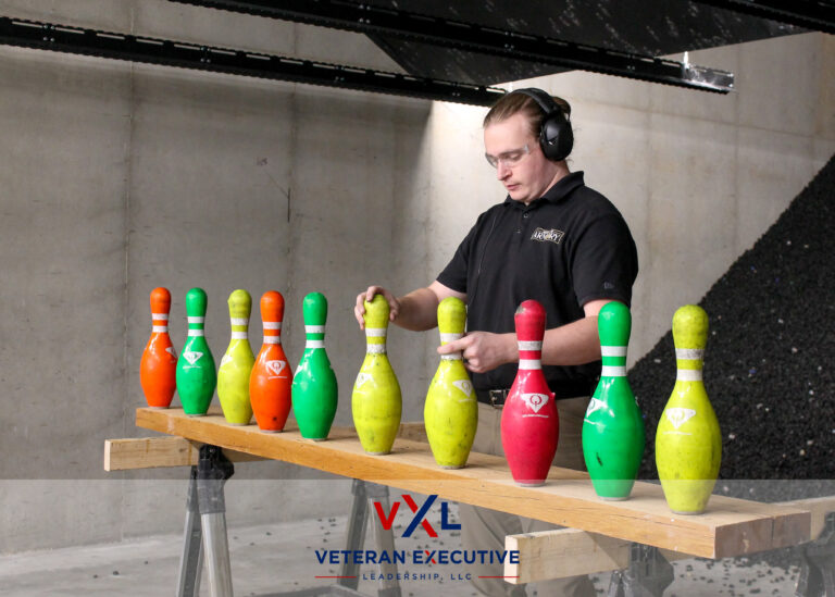 A man places colorful bowling pins on a stand to prepare them for target practice,